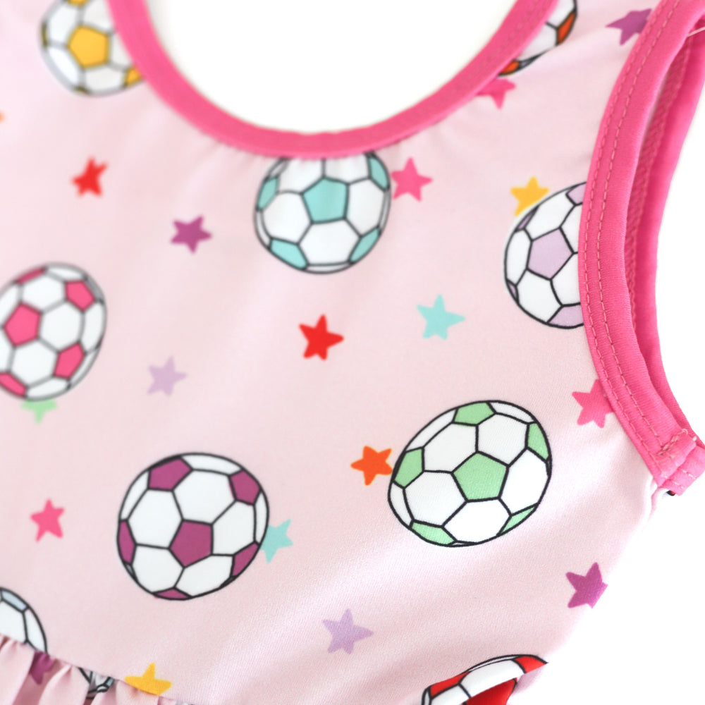 closeup of colorful soccer ball and petite star print on pastel pink dress bodice with bright pink trim