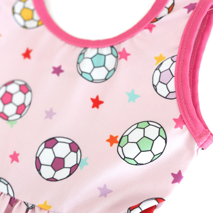closeup of colorful soccer ball and petite star print on pastel pink dress bodice with bright pink trim