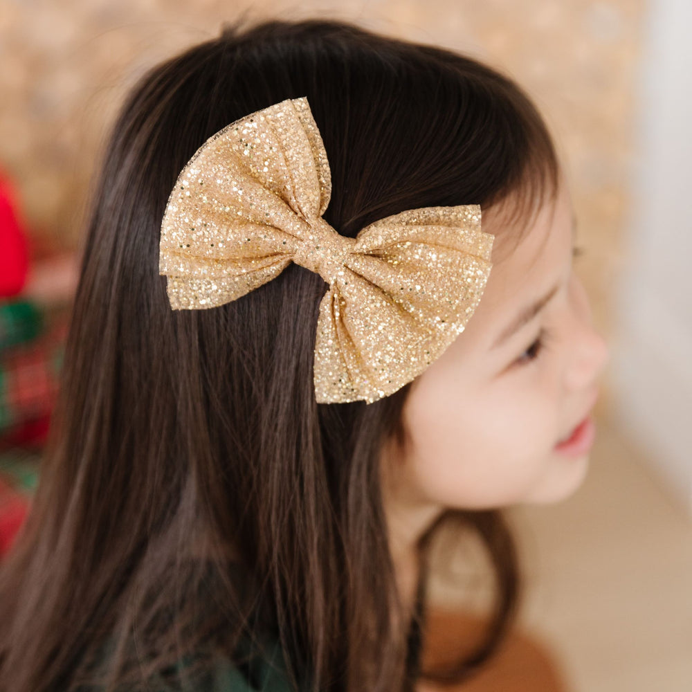 little girl in sparkly gold Christmas tutu bow 