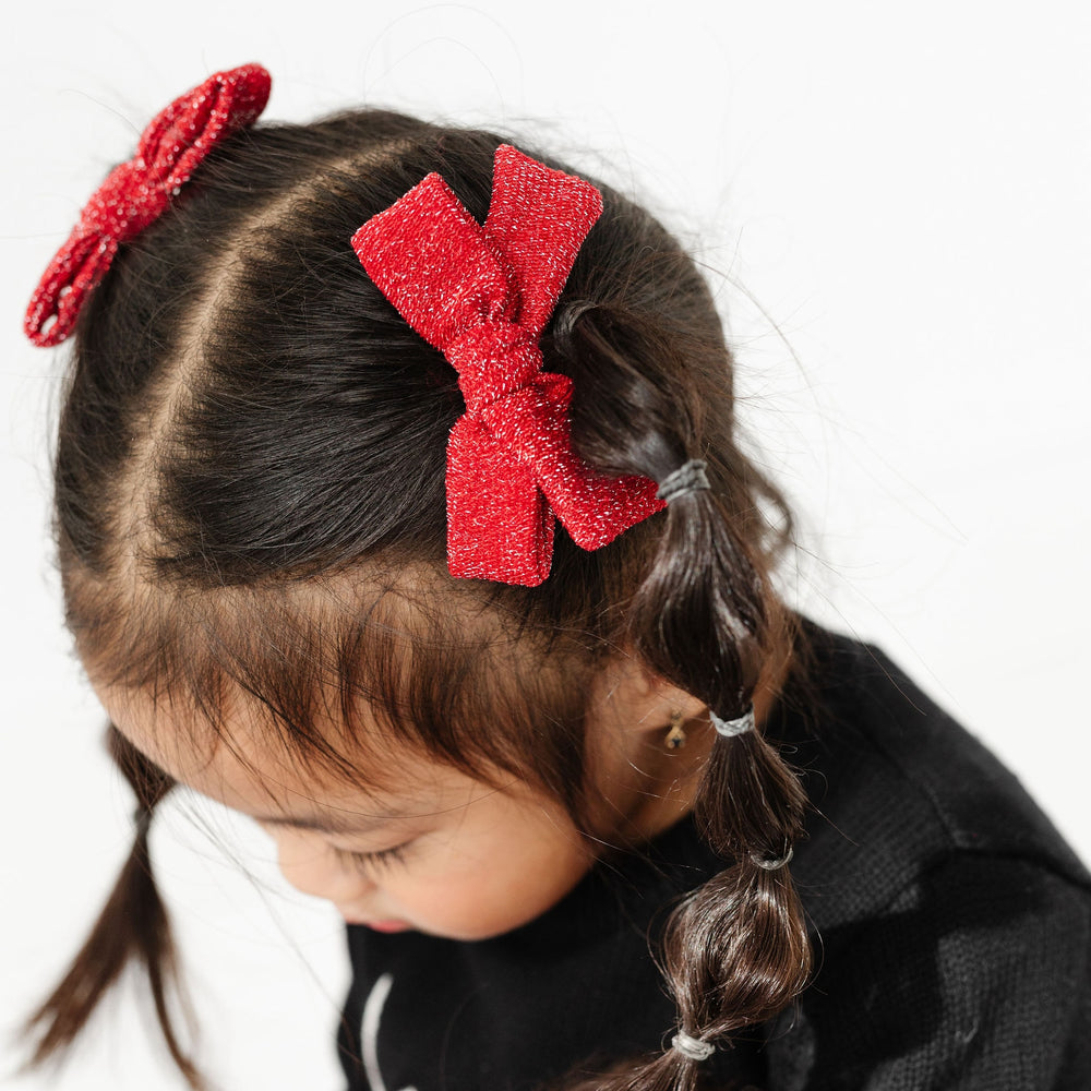 little girl with pigtails wearing sparkly red pigtail bows