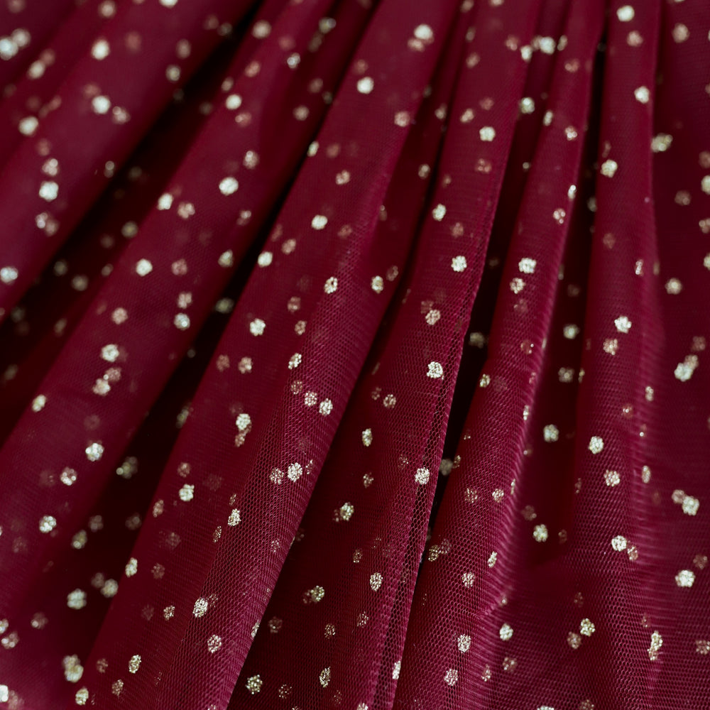 closeup of sparkly gold dots on crimson tulle