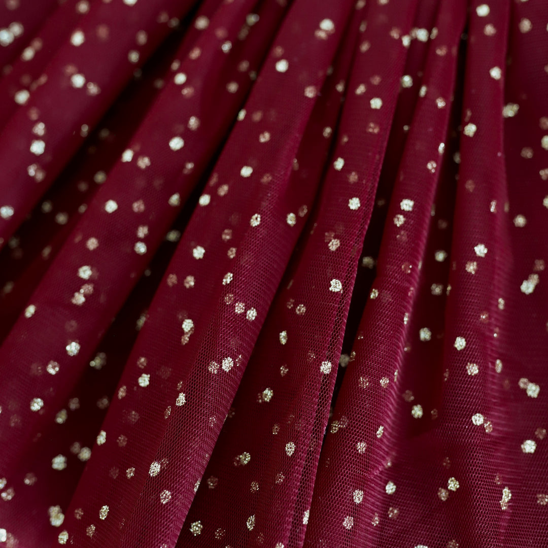 closeup of sparkly gold dots on crimson tulle