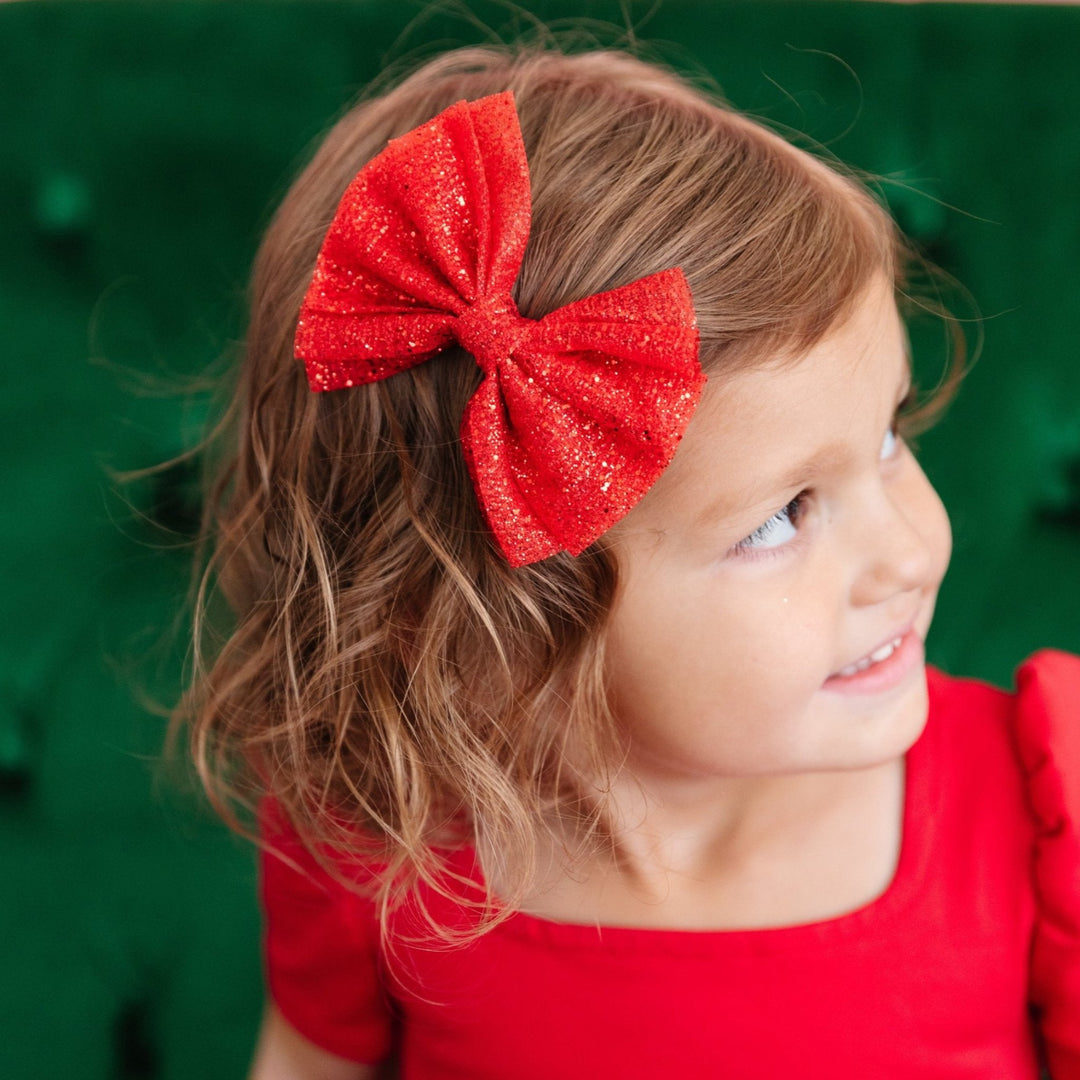 Little girl in red Christmas dress and sheer sparkly red tutu bow