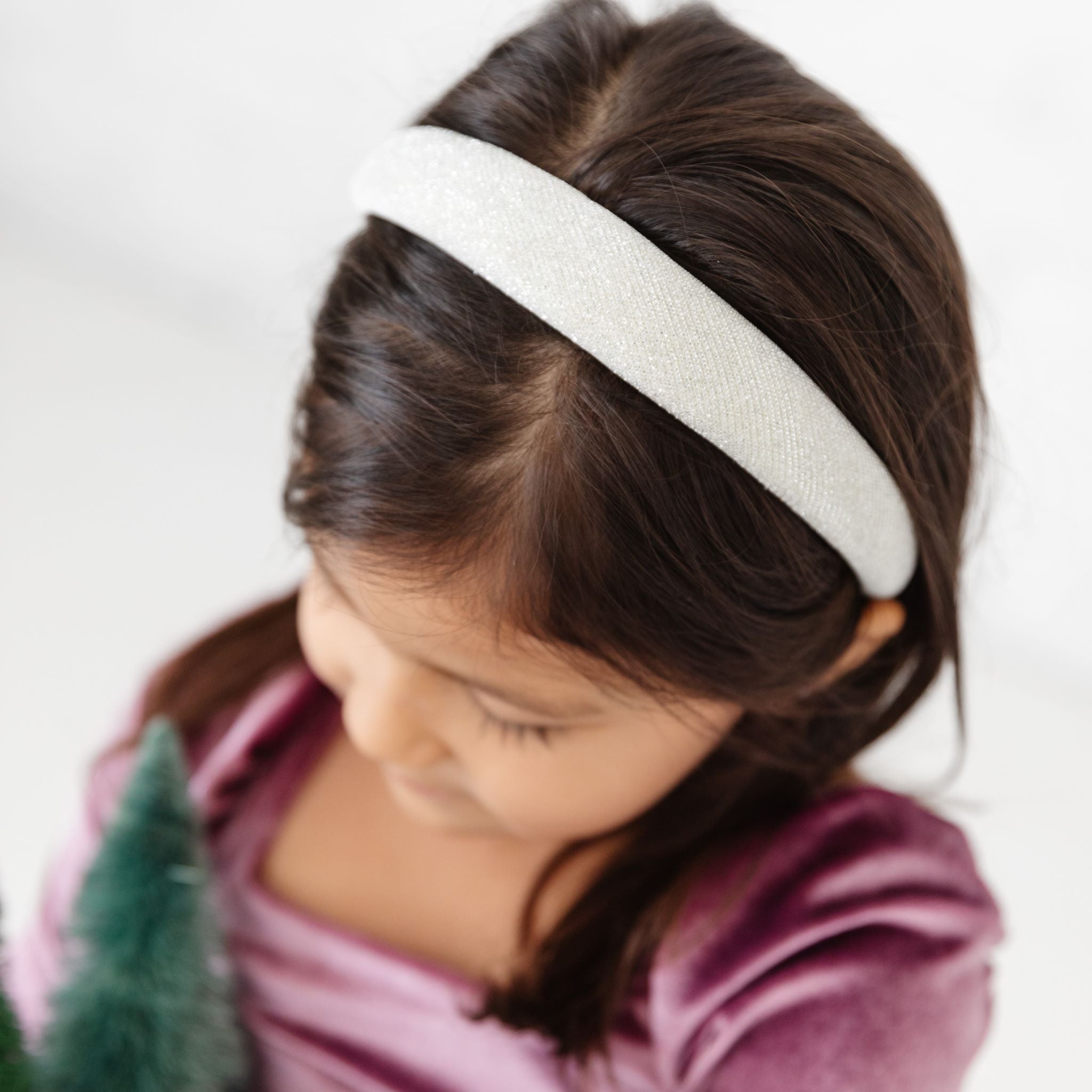 girl in padded metallic silver holiday headband and velvet dress