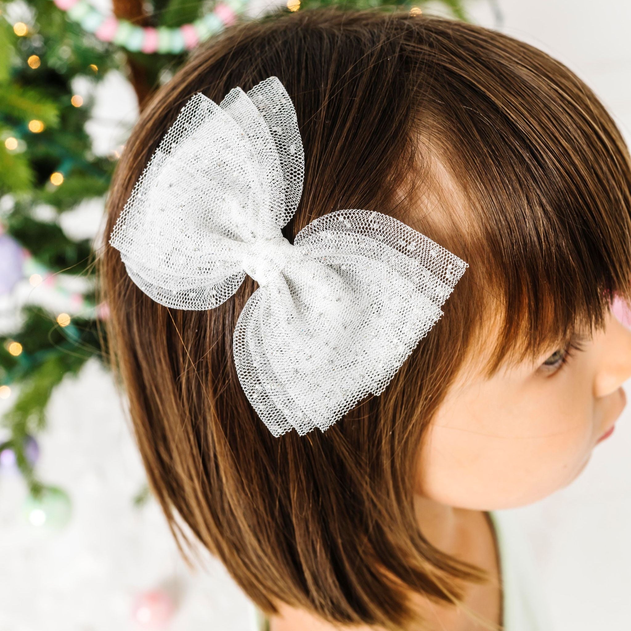 little girl in white tulle hairbow with sparkles for winter wonderland vibes