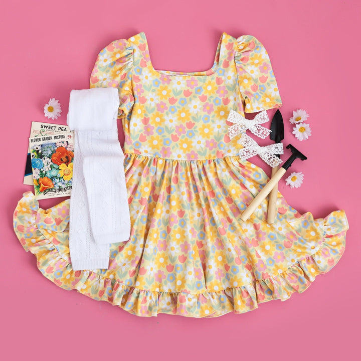 little girls spring outfit with pastel yellow square neck twirl dress with spring flower print and white fancy footless tights