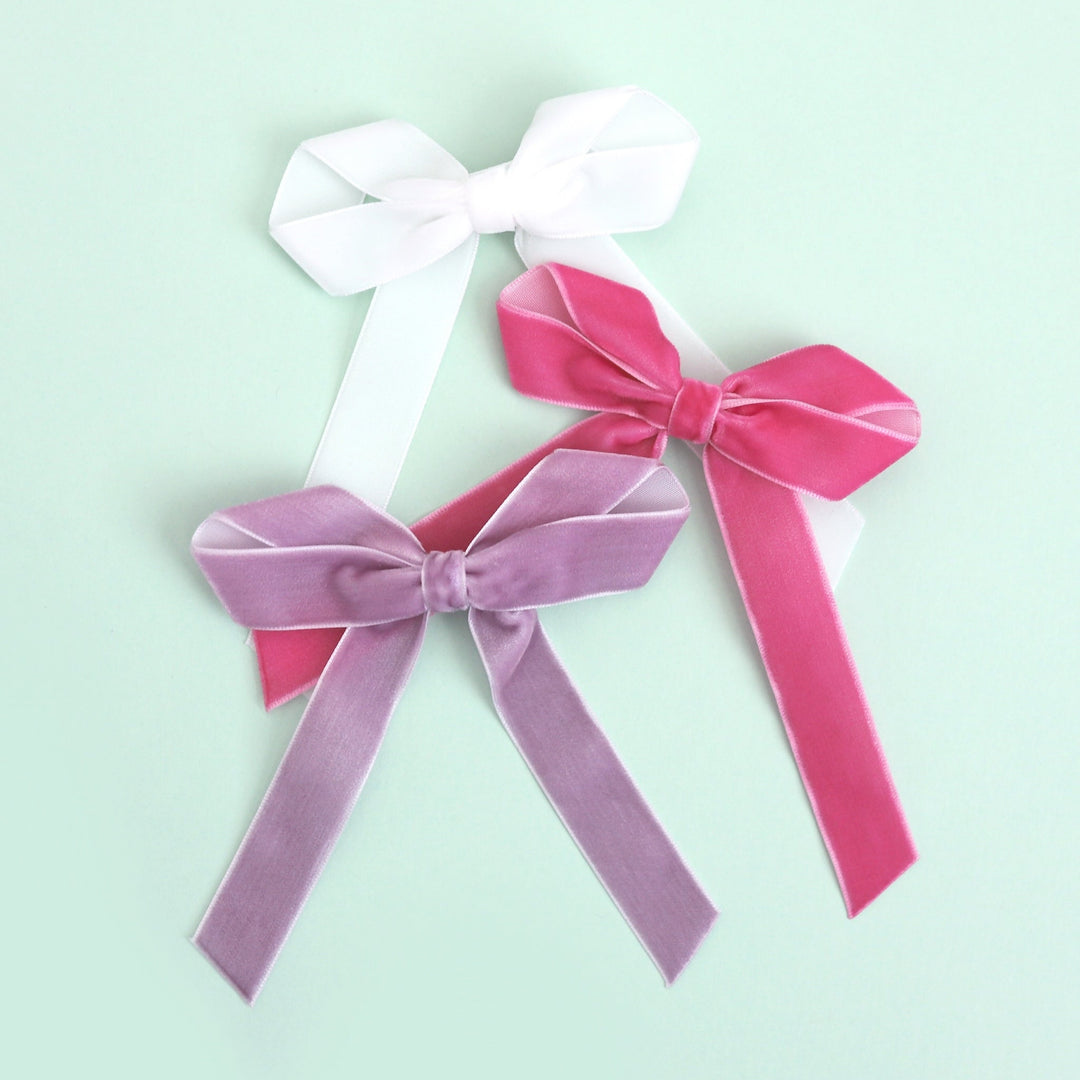 flatlay of girls' spring and easter velvet ribbon bows in white, taffy pink and lavender purple