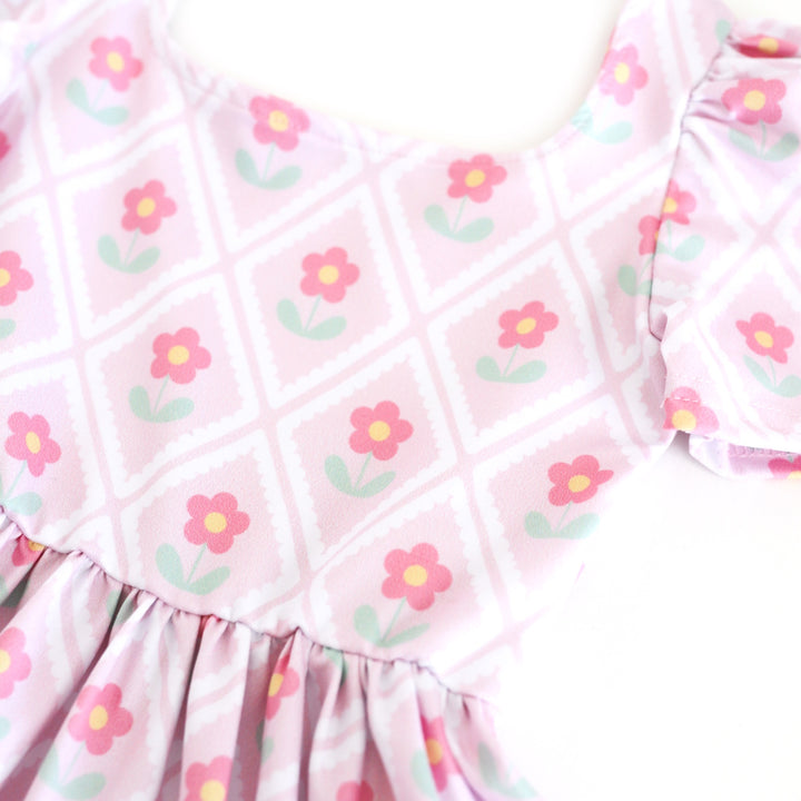 girls' light pink spring print twirl dress with cute pink daisies surrounded by scalloped diamond pattern