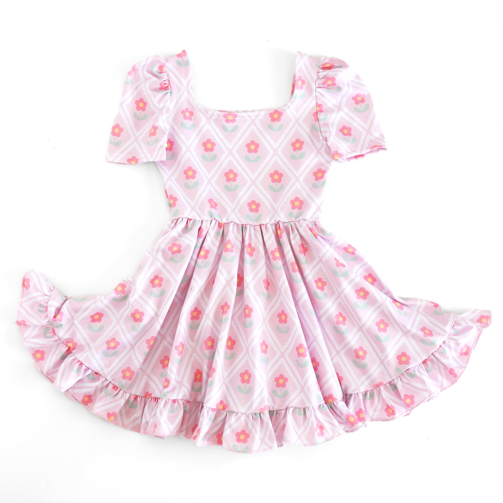 girls' light pink mod twirl dress with white diamond print surrounding and pink daisies