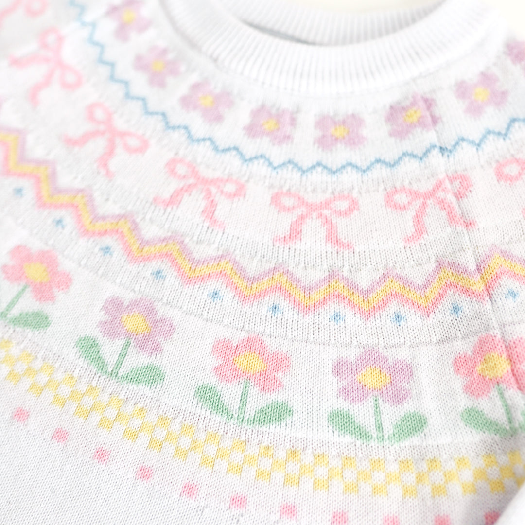 closeup of pastel spring themed fair isle pattern at the neckline of white spring sweater