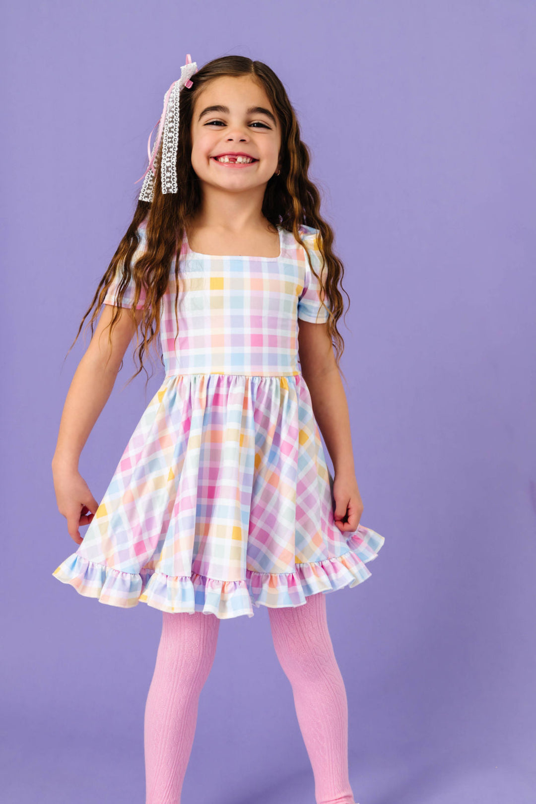 little girl in spring pastel gingham print twirl dress and matching pastel pink cable knit tights 