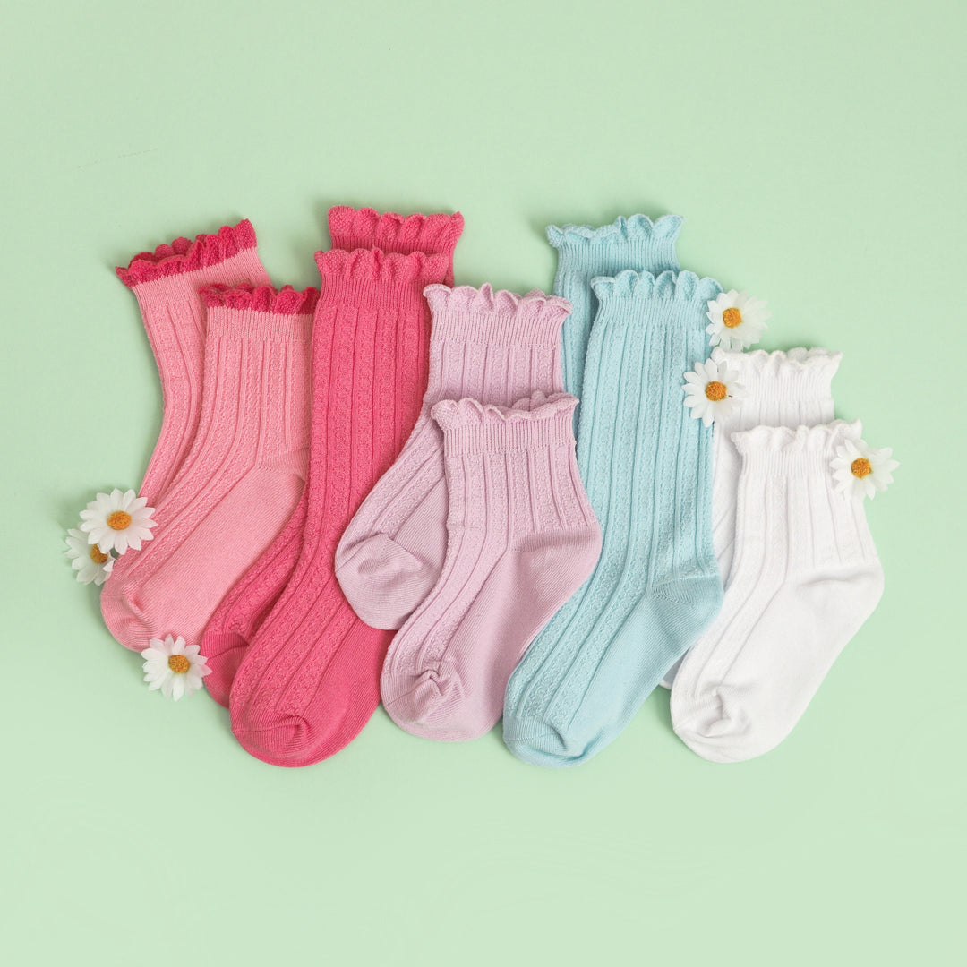 flatlay of girl's pastel scallop trimmed knee high and midi socks for spring