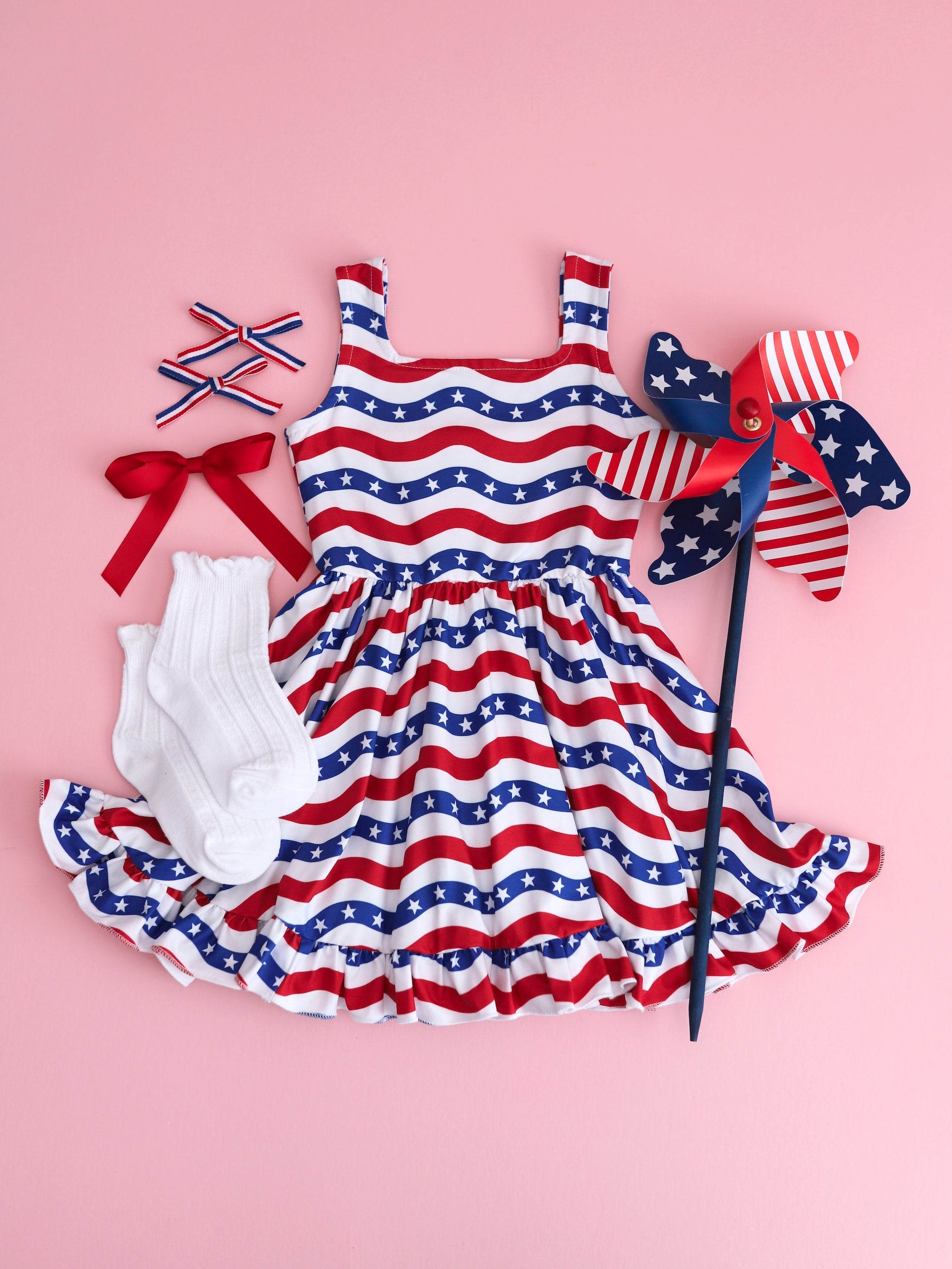 flatlay of girls red white and blue stars and stripes sleeveless dress and matching accessories
