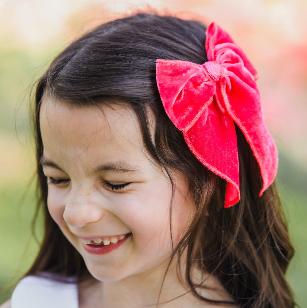 little girl wearing strawberry pink velvet hair bow