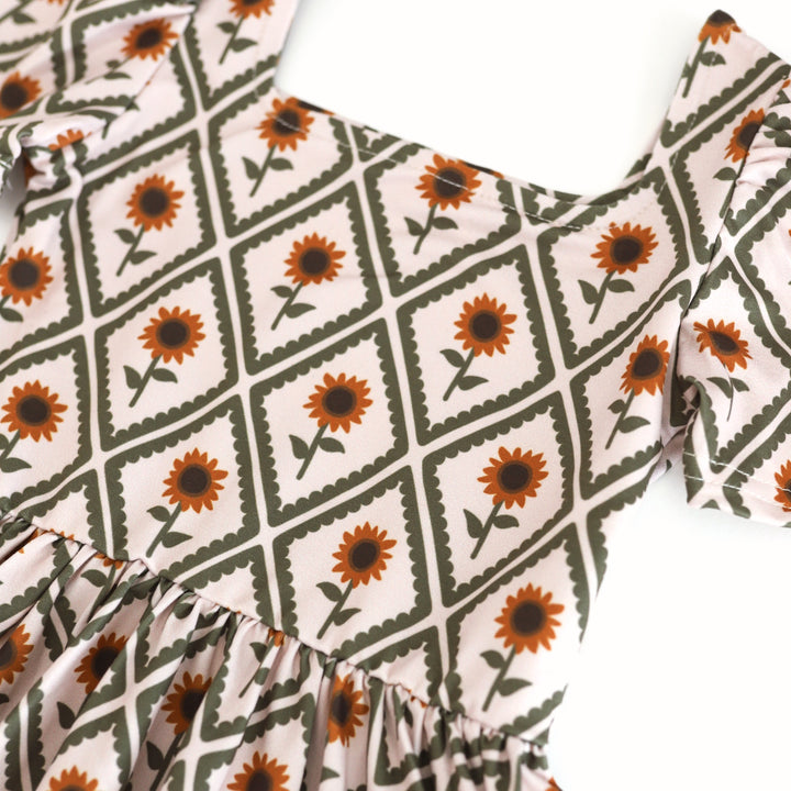 close-up of girl's twirl dress bodice with sunflower print for fall