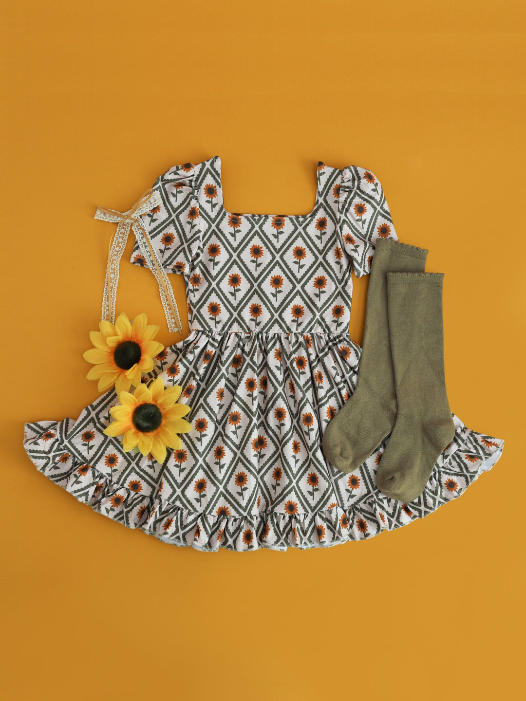 girls' square neck, short sleeve dress with sunflower and diamond print paired with olive knee high socks and lace bow for sunflower field photos