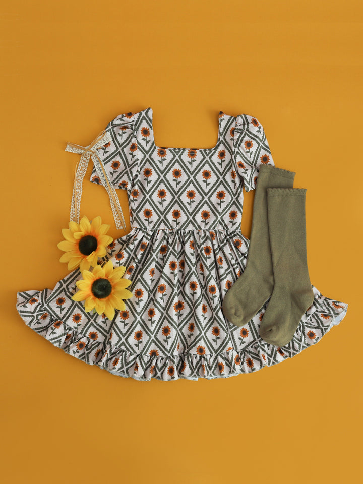 girls' square neck, short sleeve dress with sunflower and diamond print paired with olive knee high socks and lace bow for sunflower field photos
