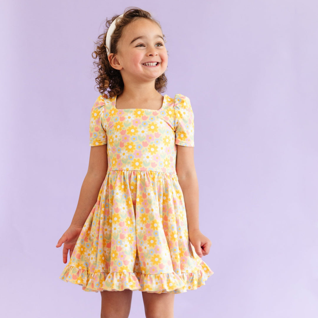 little girl in yellow spring floral twirl dress and white headband