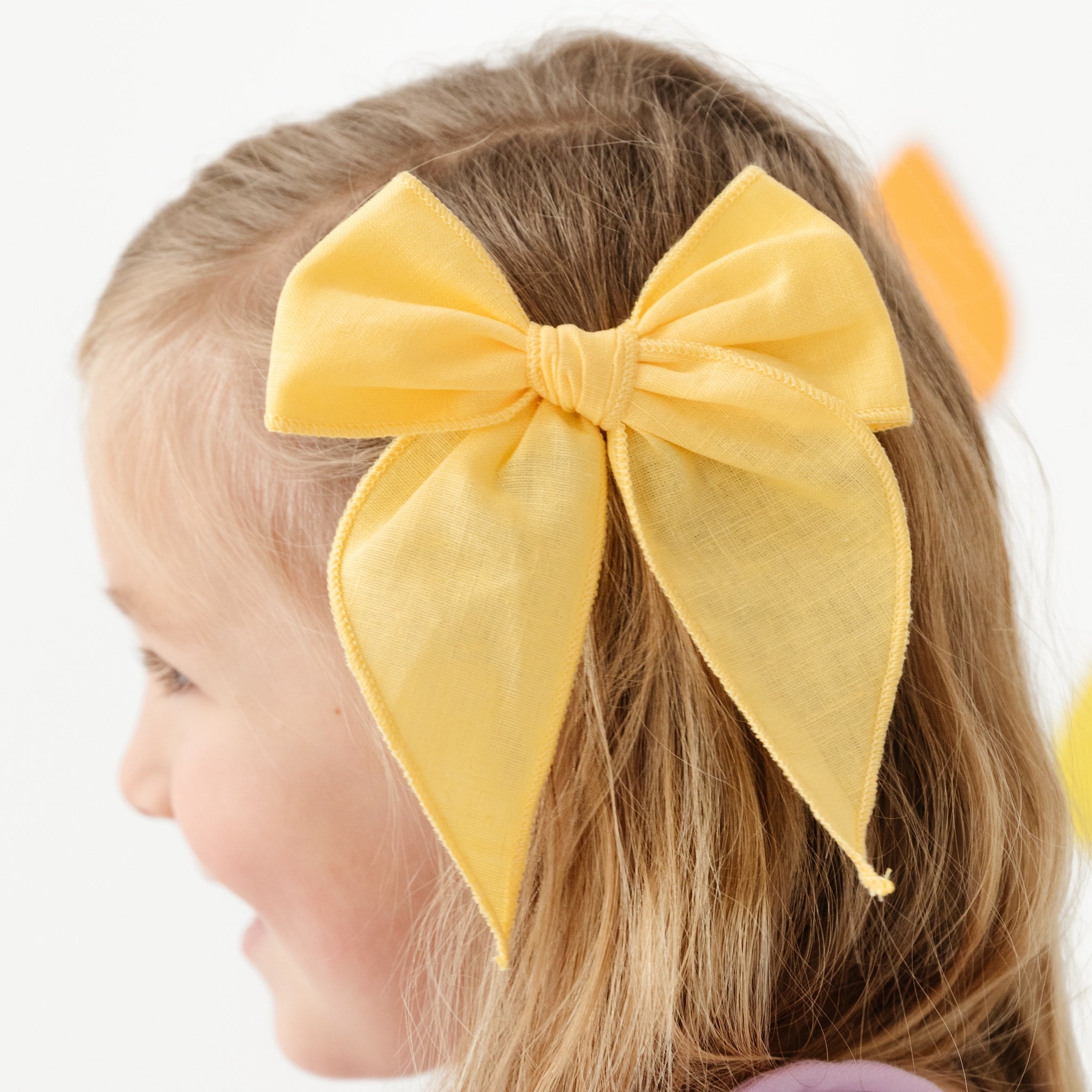 girl in sunshine yellow linen party bow