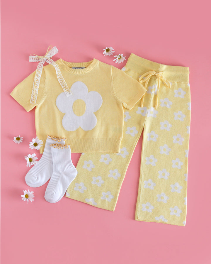 girls' spring sweater set with pastel yellow short sleeve flower knit top and matching yellow sweater pants with white flowers paired with yellow lettuce trim midi socks and matching hair bow