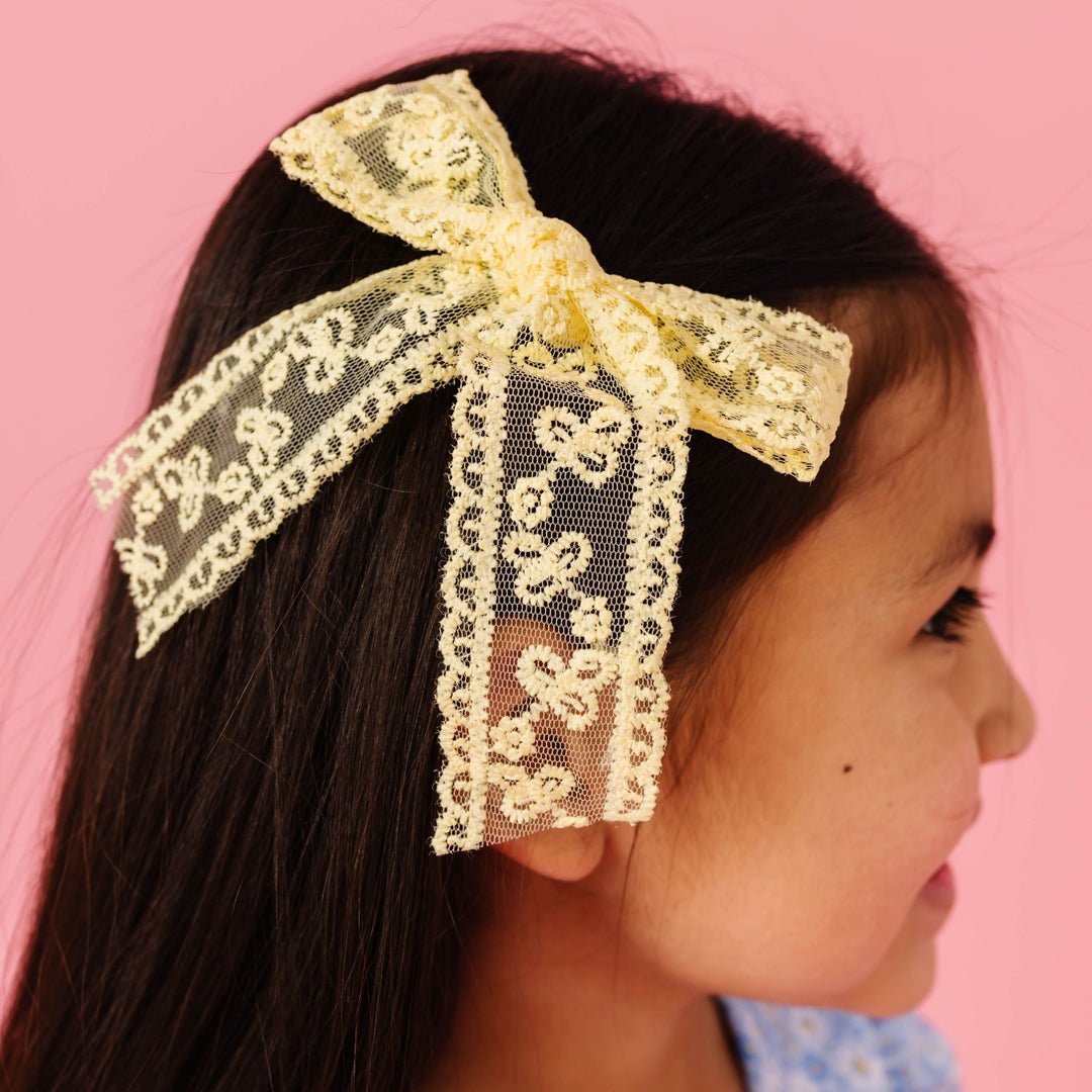 young girl in pastel yellow lace hair bow on alligator clip