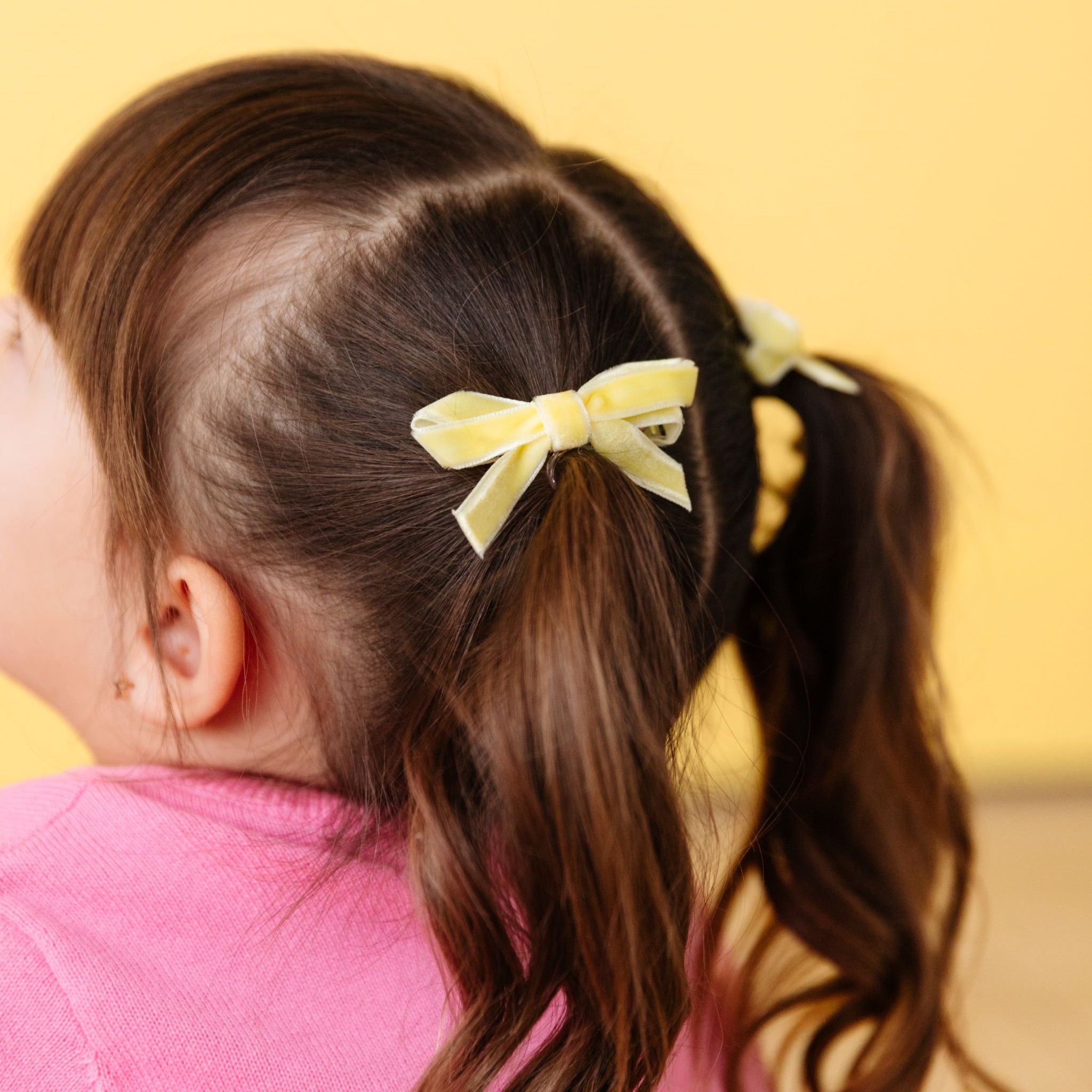 closeup of little girl in pigtails with pastel velvet ribbon pigtail bows on clips for spring