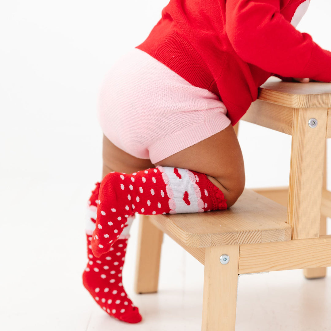 closeup of baby girl's pink cotton knit sweater bloomers and matching red Valentine's Dat themed knee highs