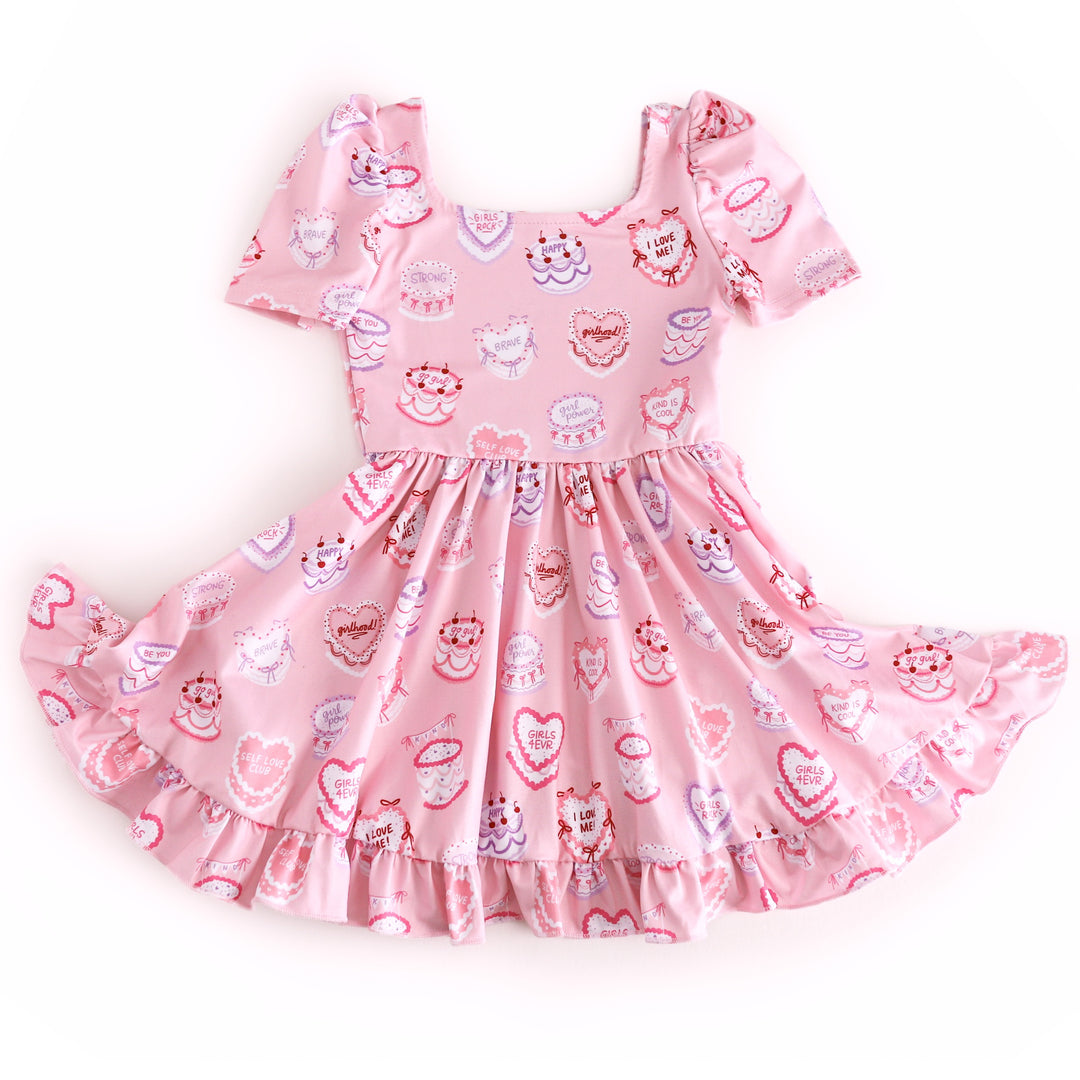 girls' light pink, short sleeve twirl dress with valentine's inspired cake print featuring words of affirmation