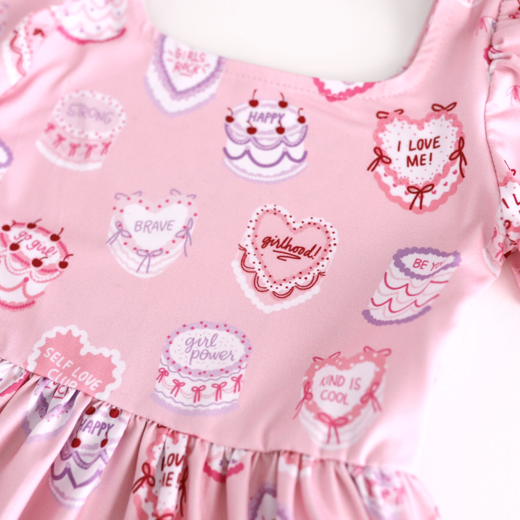 print closeup for pink Valentine's cake print dress with words of affirmation for girlhood