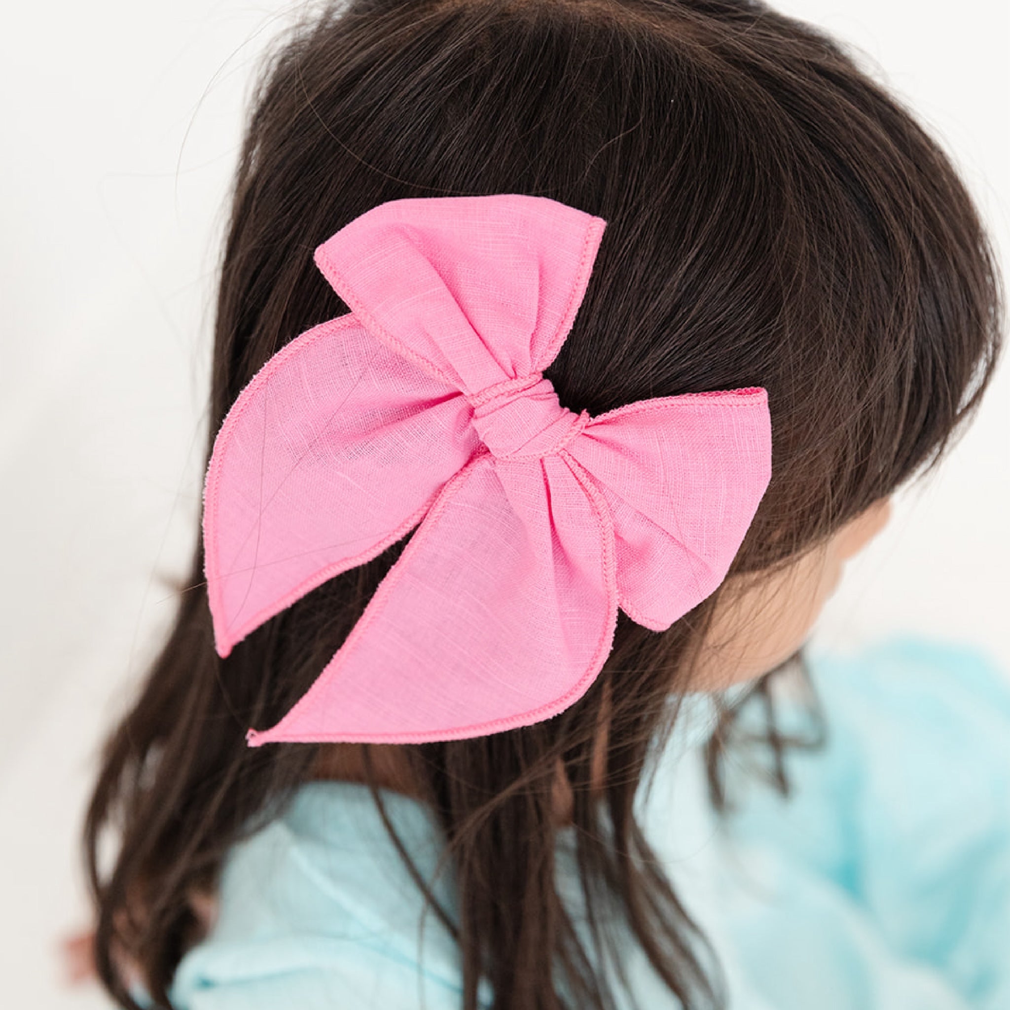 girl wearing bright pink girls hair bow