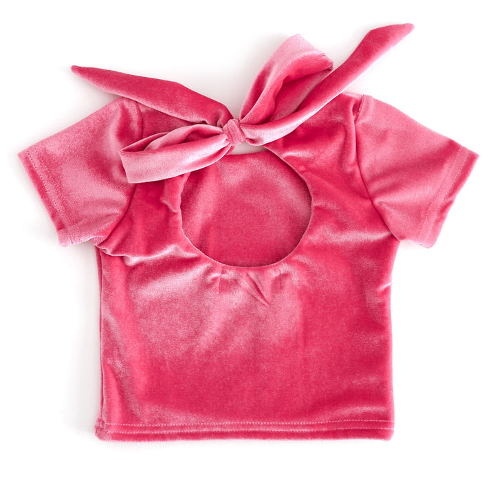 back view of girls pink velvet top with keyhole opening and large tied bow closure 