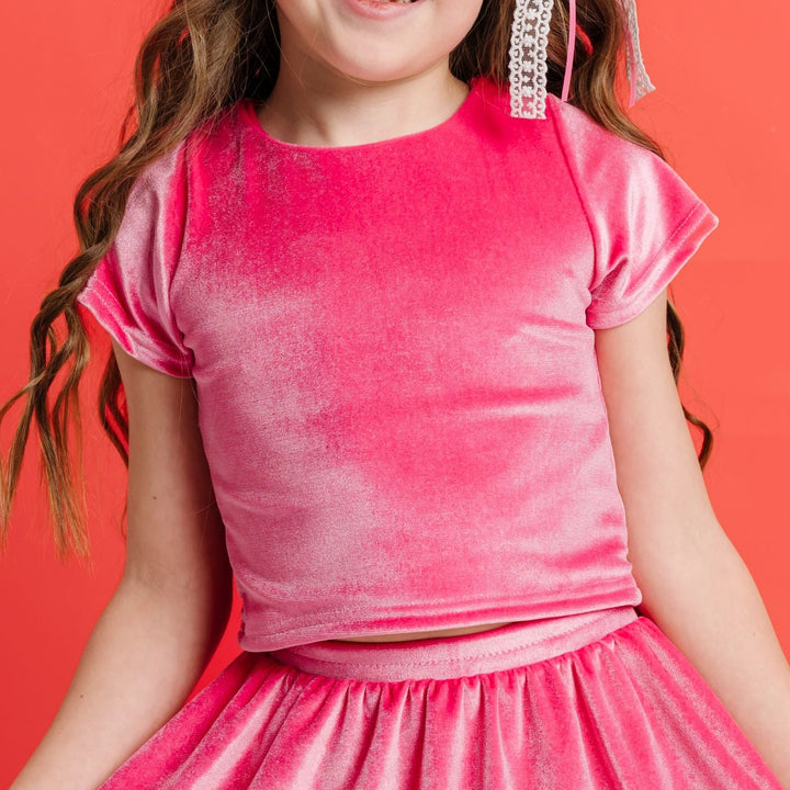 closeup of fitted pink velvet top with matching skort on little girl