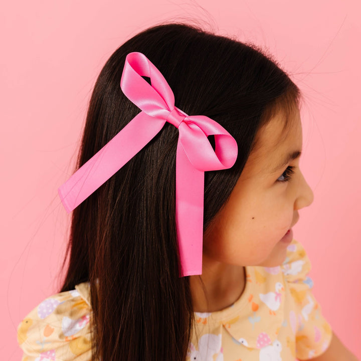 girl in pastel yellow easter themed twirl dress and matching pink satin hair bow on clip