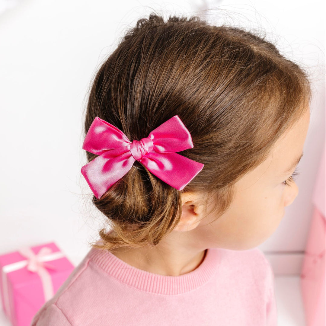 little girl in pink satin pigtail bows on clips for pink Christmas and winter wonderland outfits