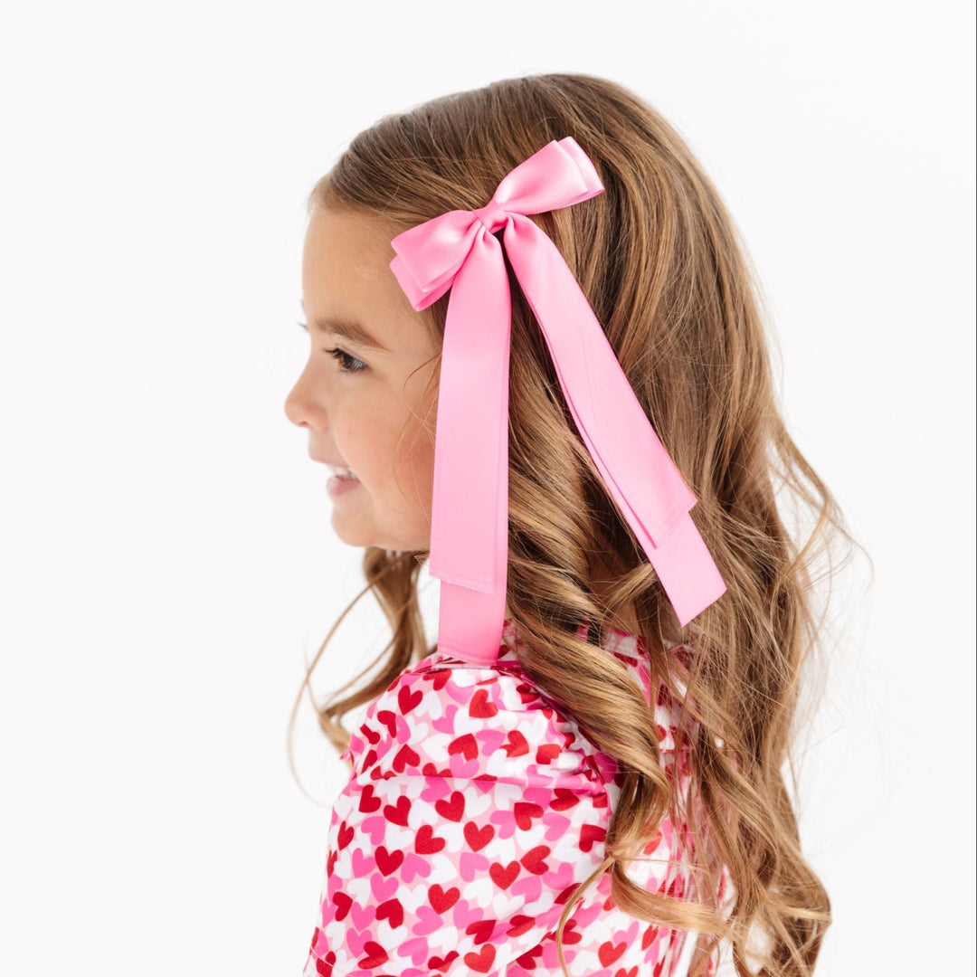 little girl in pink satin long tail Valentine's bow and made to match pink and red heart dress