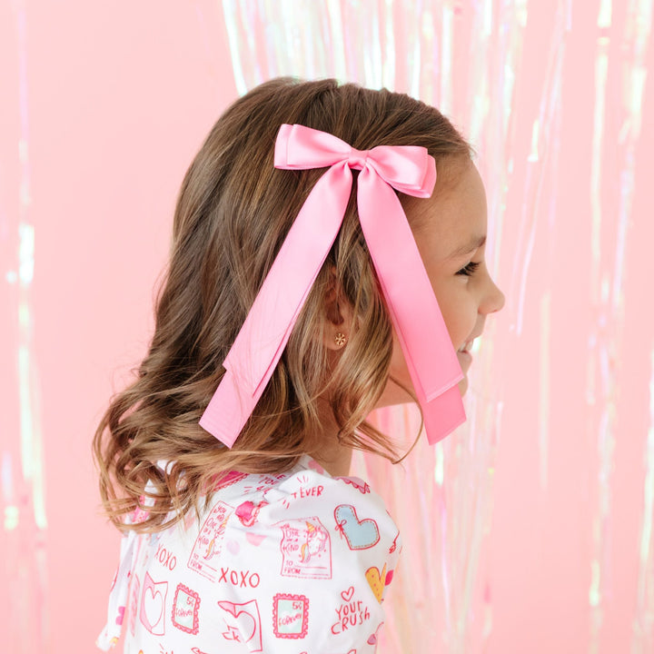 little girl in pink satin ribbon bow with matching Valentine's Day print dress