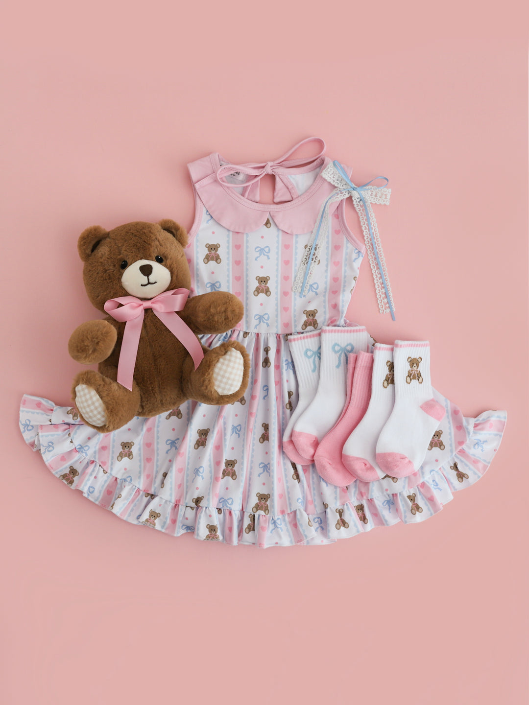 girls' vintage teddy bear print sleeveless dress with pink trim and peter pan collar in shades of pink, white and blue paired with matching crew sock 3-pack and lace ribbon hair bow