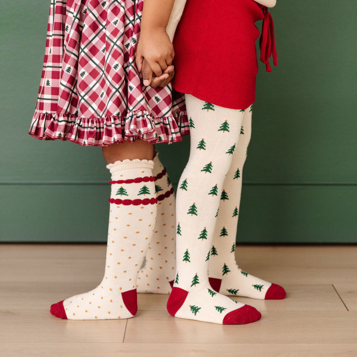 little girls in coordinating outfits with tree farm inspired knee high socks and patterned tights with trees