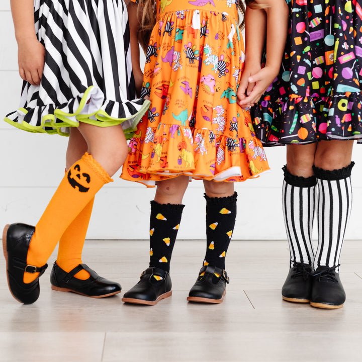 little girls in halloween dresses wearing cute halloween knee high socks