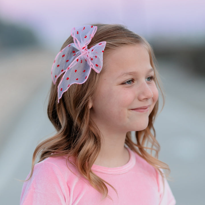 little girl in pink sheer bow with red dots and matching pink velvet valentine's dress