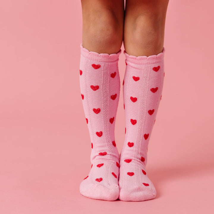 girl in light pink scallop trimmed knee high socks with red heart pattern for valentines day