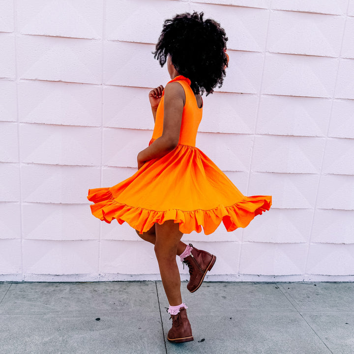 little girl twirling in orange summer twirl dress