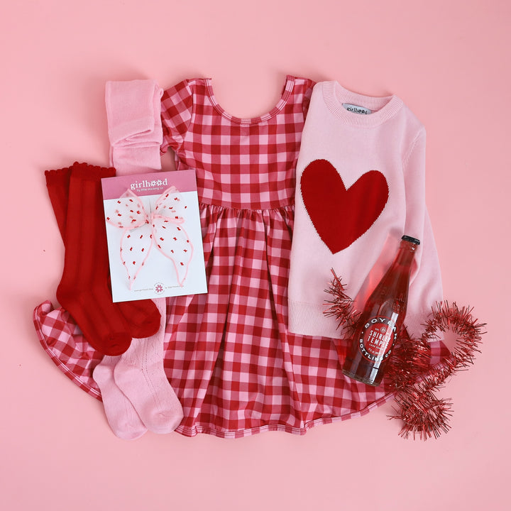 girls valentine's outfit with red and pink gingham scoop neck dress, pink and red heart sweater and fancy knit tights and knee high socks