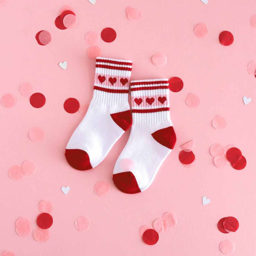 white valentines day athletic crew socks with red and pink heart and stripe design on ribbed cuffs