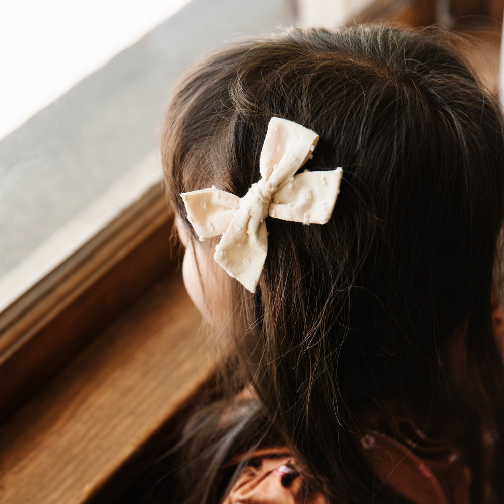 vanilla dot pigtail bow on little girl with long brown hair