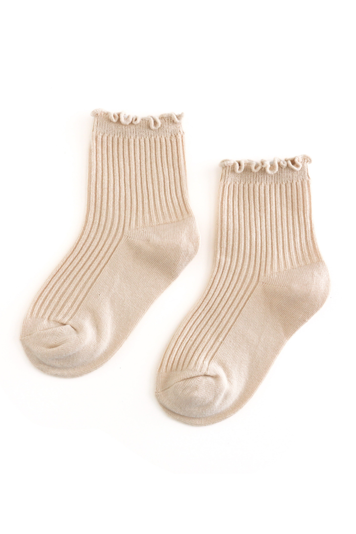 A pair of ribbed ankle socks in a light beige or cream color, featuring a delicate ruffled trim along the top cuff, displayed on a clean white background.