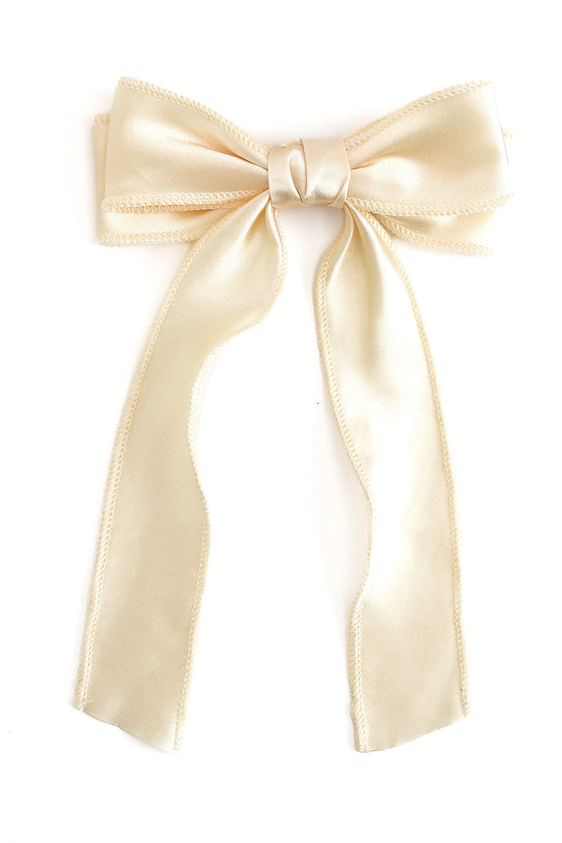 A cream-colored satin ribbon bow with long tails, photographed against a solid white background.