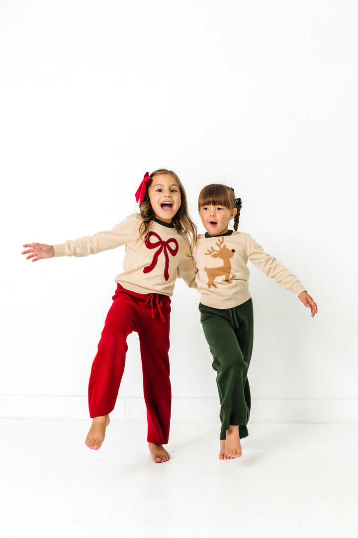 children playing Christmas sweater sets featuring red bow and reindeer designs