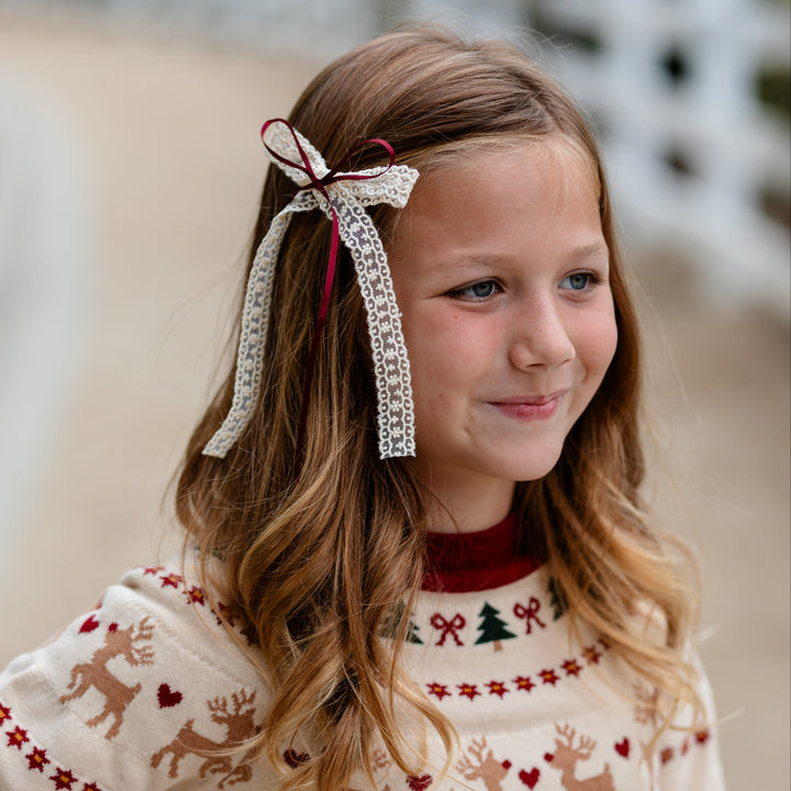 young girl in cream long tail ribbon bow with crimson satin ribbon on clip