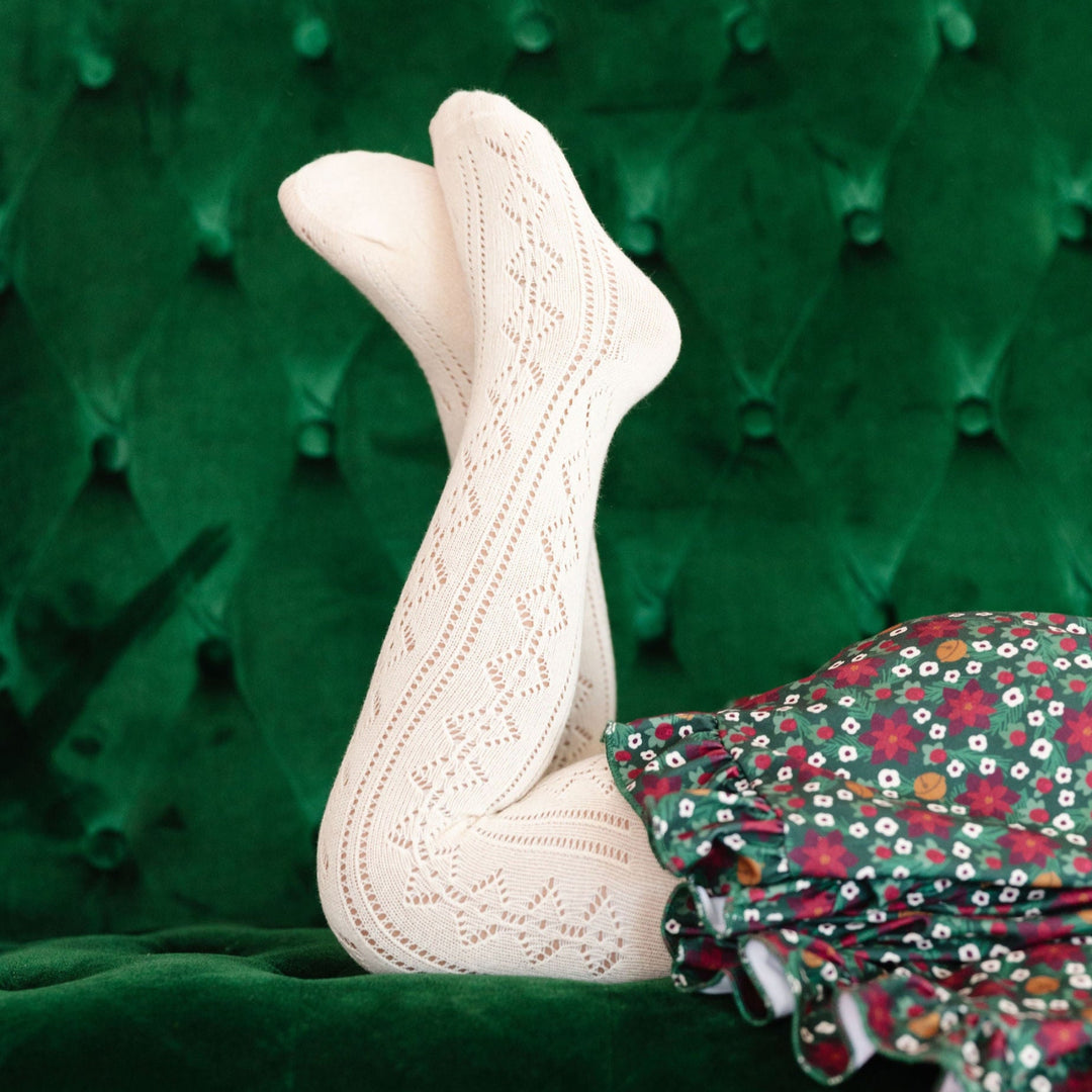 little girl in Ivory pointelle knit tights and Poinsettia print holiday dress 